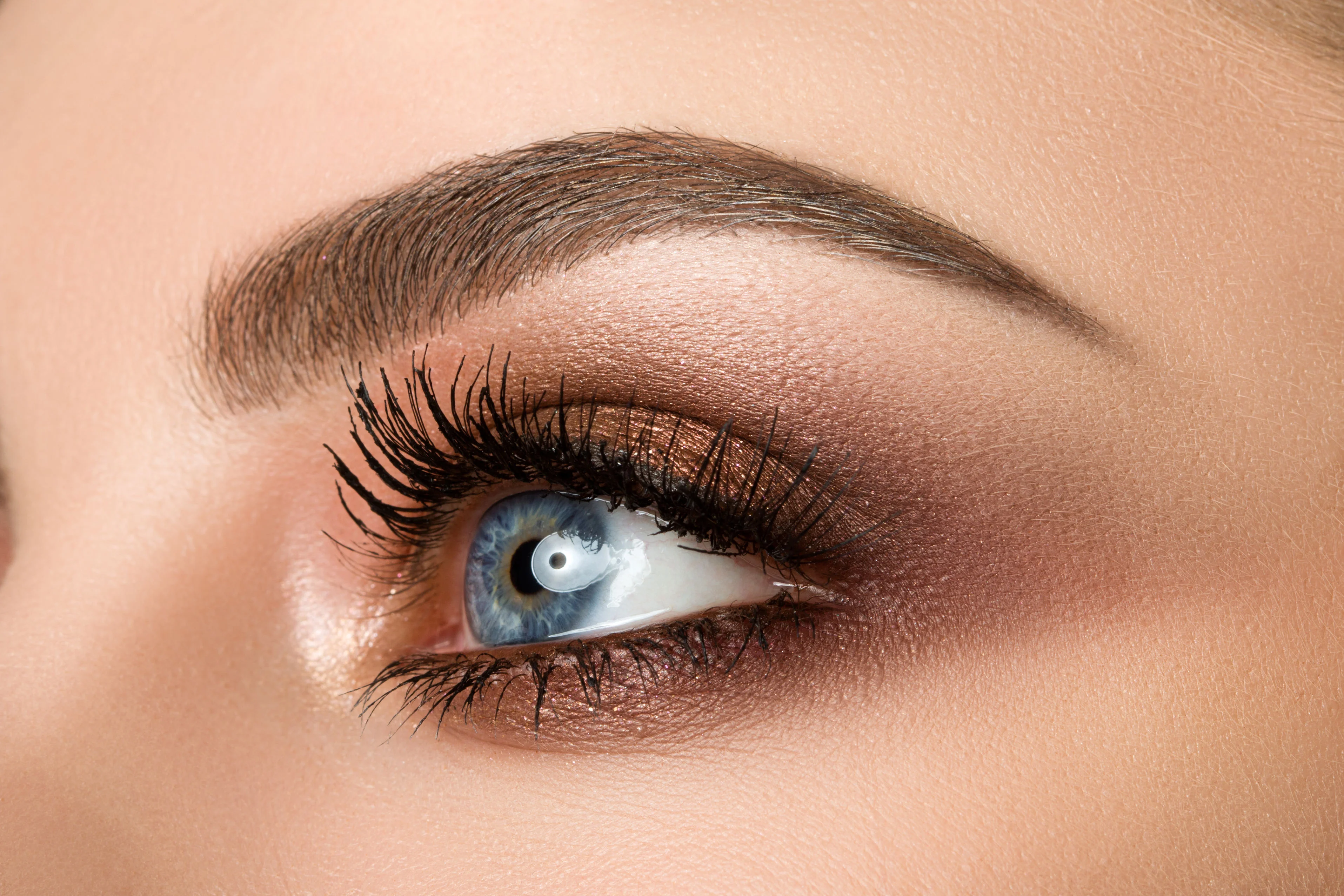 56057664 - close up of blue woman eye with beautiful brown with red and orange shades smokey eyes makeup. modern fashion make up.