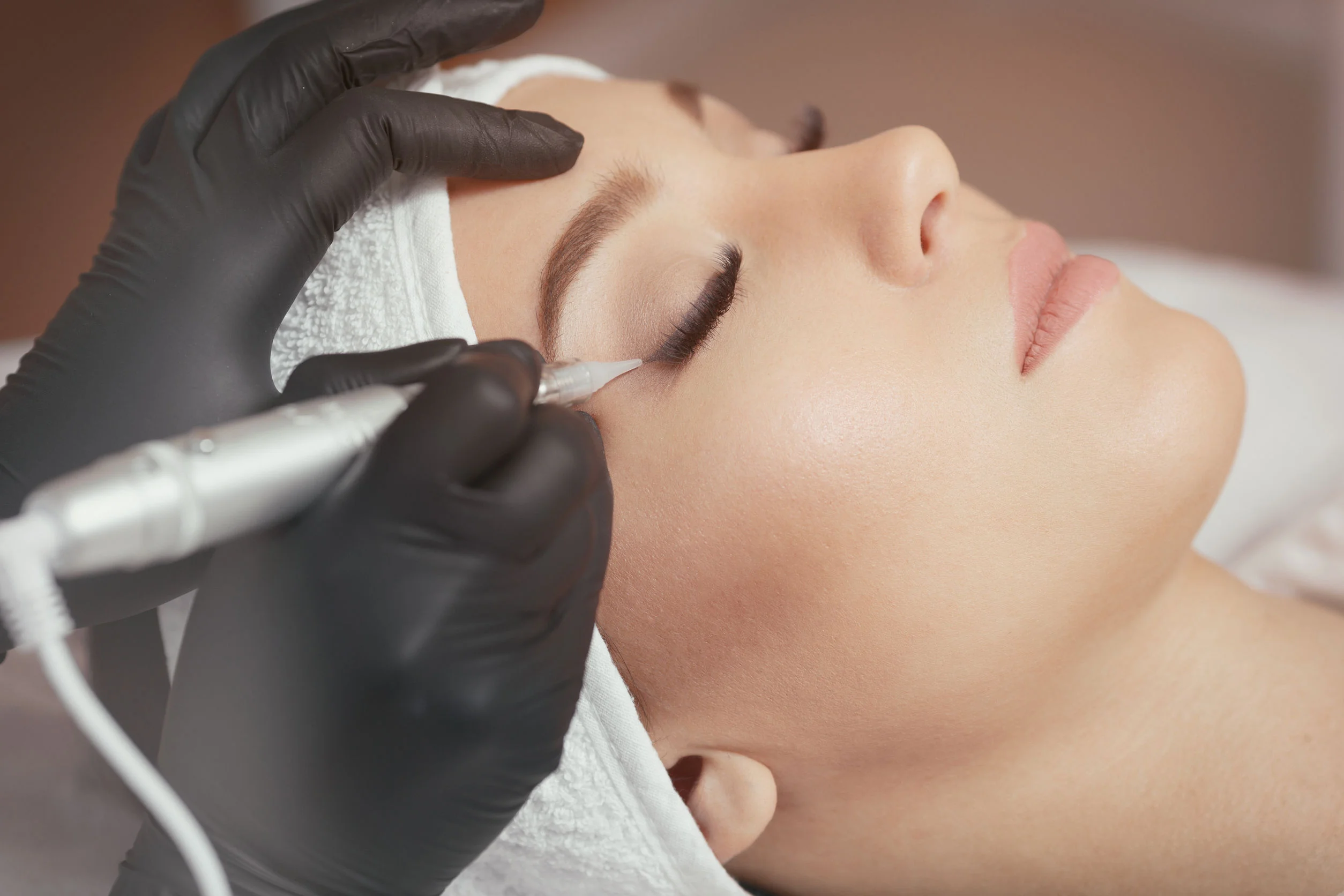 70266856 - close up cosmetologist making eyeliner permanent makeup